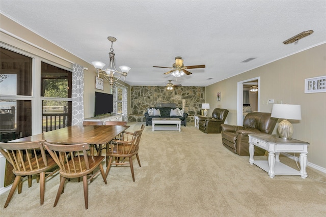 dining area featuring light colored carpet, a textured ceiling, ceiling fan with notable chandelier, and crown molding