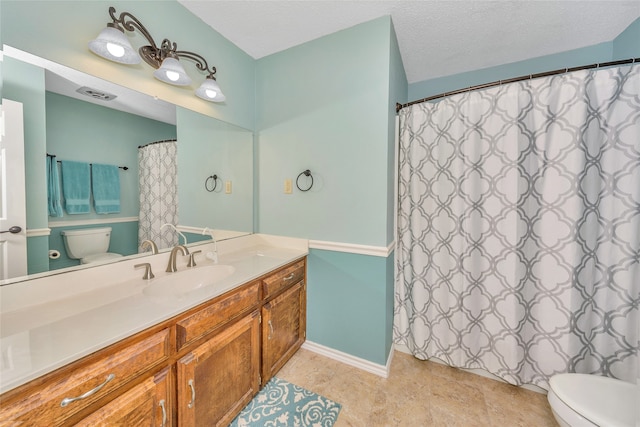 bathroom with tile patterned floors, toilet, a textured ceiling, and vanity