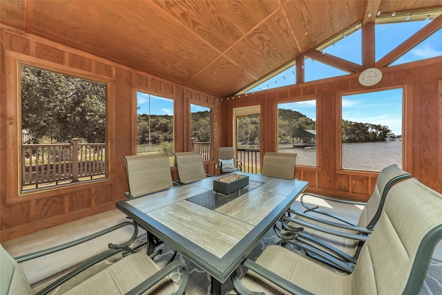 sunroom with a water view, lofted ceiling, wood ceiling, and a healthy amount of sunlight