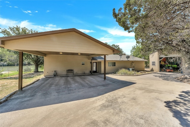 view of front of property featuring a carport and an outbuilding