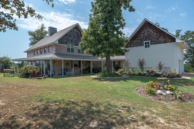 rear view of property featuring a chimney and a yard