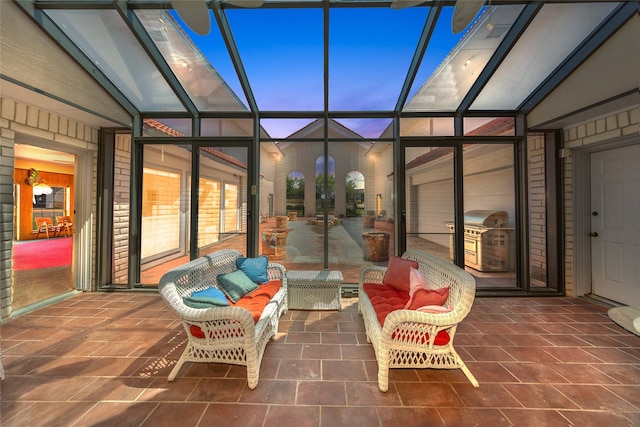 patio terrace at dusk with glass enclosure and area for grilling