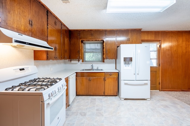 kitchen featuring sink, plenty of natural light, a textured ceiling, and white appliances