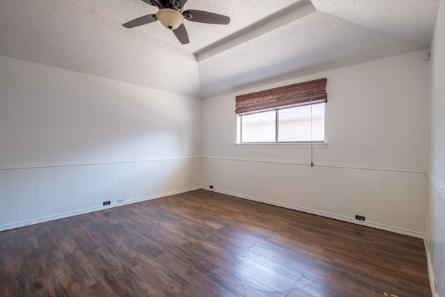 unfurnished room with a textured ceiling, ceiling fan, dark wood-type flooring, and vaulted ceiling