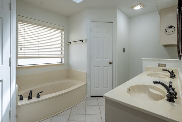 bathroom with tile patterned flooring, a bathtub, and vanity