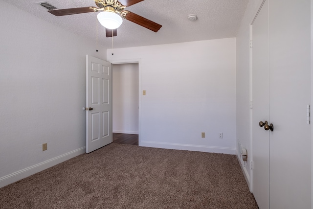 carpeted spare room featuring ceiling fan and a textured ceiling