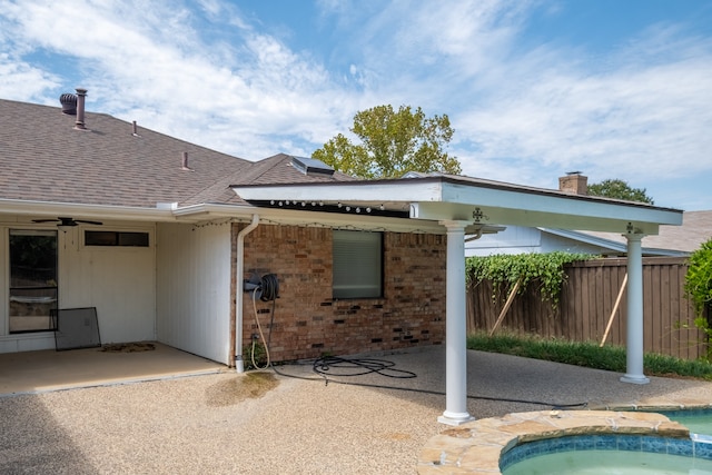 rear view of property with ceiling fan, a fenced in pool, and a patio