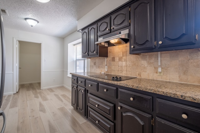 kitchen with decorative backsplash, light hardwood / wood-style flooring, light stone counters, black electric cooktop, and a textured ceiling