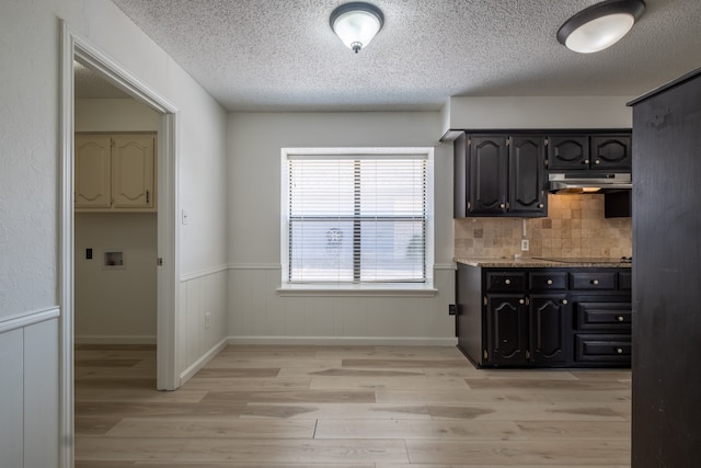 kitchen featuring backsplash, light hardwood / wood-style flooring, and a textured ceiling