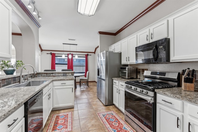 kitchen with stainless steel appliances, decorative light fixtures, ornamental molding, white cabinets, and track lighting