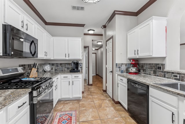 kitchen featuring crown molding, decorative backsplash, light tile patterned floors, and black appliances