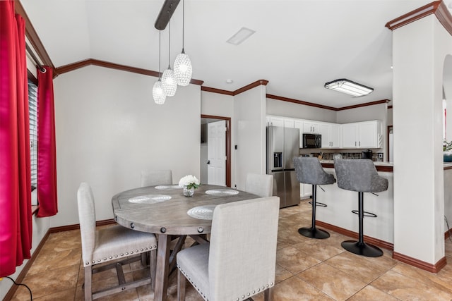 dining space with ornamental molding and light tile patterned floors