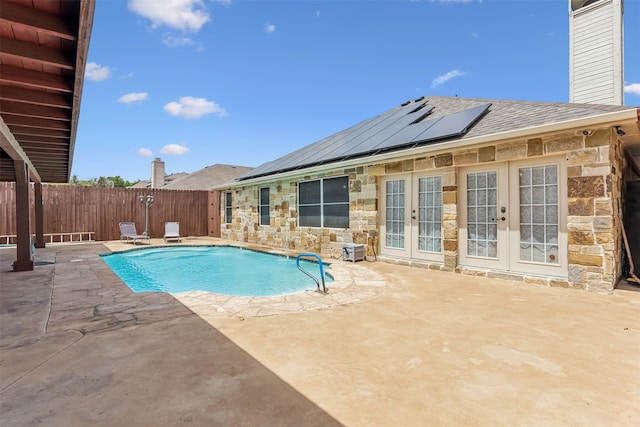 view of swimming pool with a patio and french doors