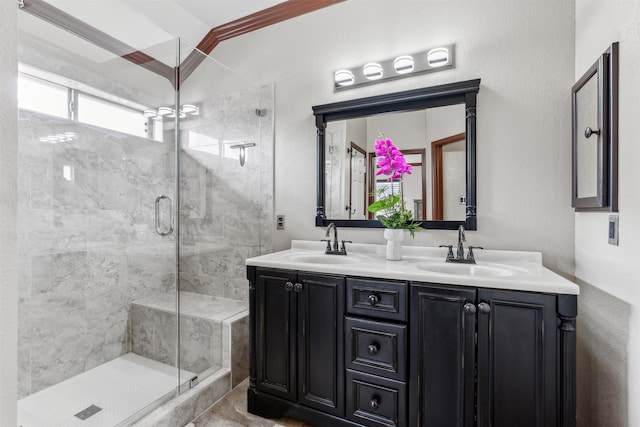 bathroom with ornamental molding, vanity, and a shower with shower door