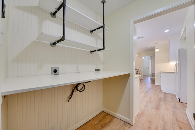 clothes washing area with light wood-type flooring