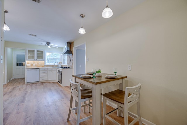 dining area featuring ceiling fan, light hardwood / wood-style flooring, and sink