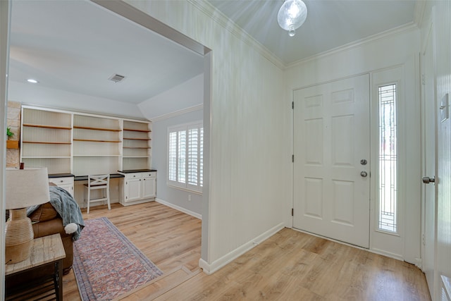 entrance foyer featuring light hardwood / wood-style floors, crown molding, and vaulted ceiling