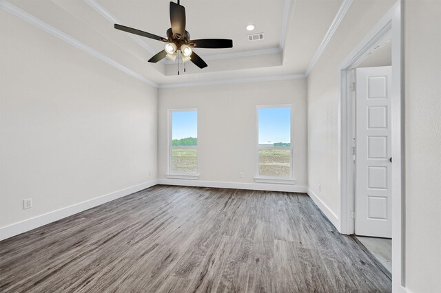 unfurnished room featuring ceiling fan, crown molding, a tray ceiling, and wood-type flooring