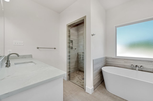 bathroom with tile patterned floors, separate shower and tub, and vanity