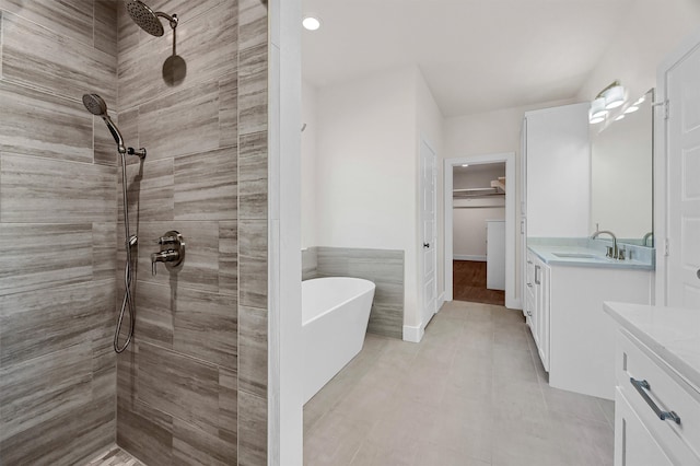 bathroom featuring tile patterned flooring, separate shower and tub, and vanity