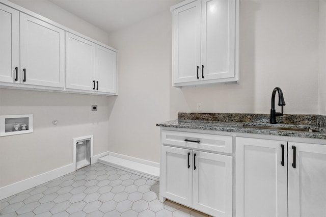 laundry area featuring cabinets, hookup for an electric dryer, light tile patterned floors, sink, and gas dryer hookup