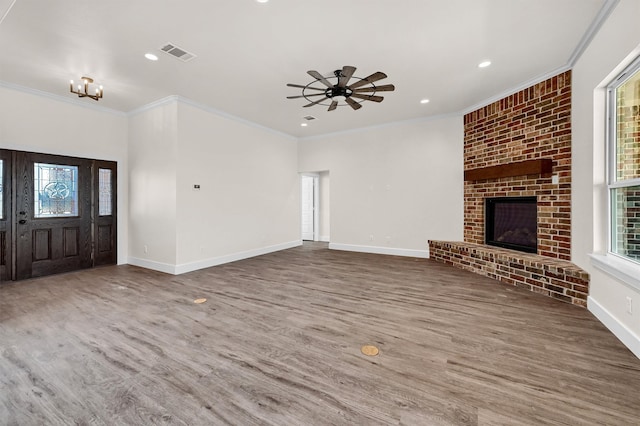 unfurnished living room with hardwood / wood-style flooring, a fireplace, crown molding, and ceiling fan