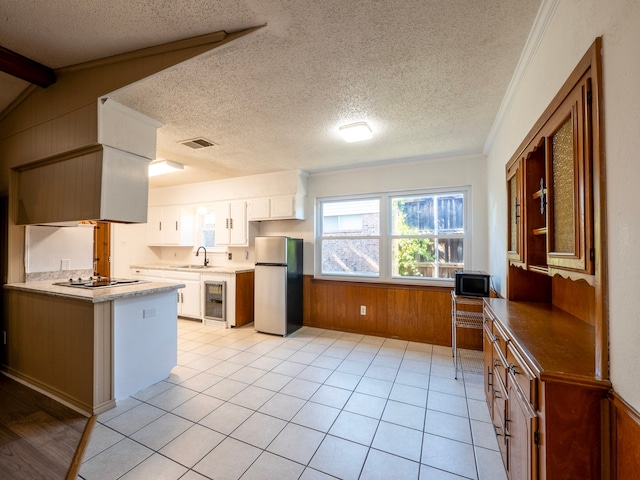 kitchen featuring a textured ceiling, appliances with stainless steel finishes, sink, and white cabinets