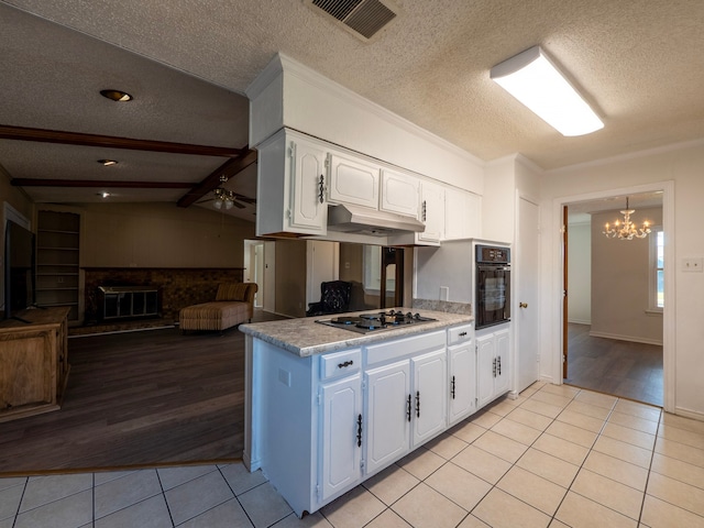 kitchen featuring stainless steel gas stovetop, a textured ceiling, oven, white cabinetry, and light wood-type flooring