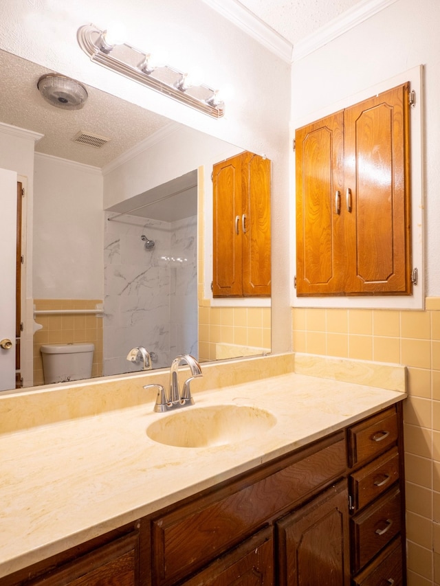 bathroom with tile walls, a tile shower, vanity, a textured ceiling, and toilet