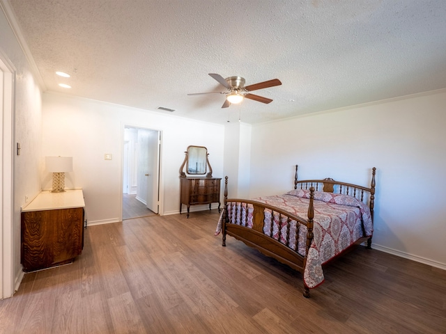 bedroom featuring hardwood / wood-style floors, ceiling fan, a textured ceiling, and crown molding