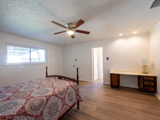 bedroom with crown molding, hardwood / wood-style floors, ceiling fan, and a textured ceiling