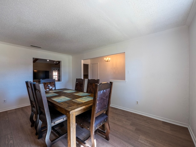 dining space featuring dark hardwood / wood-style flooring, a notable chandelier, a textured ceiling, and crown molding