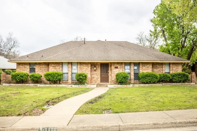 single story home with brick siding, a front yard, and a shingled roof