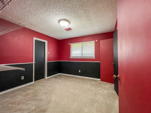 empty room with a textured ceiling and carpet floors