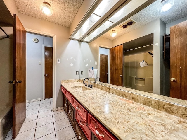 bathroom with tile patterned flooring, a textured ceiling, and vanity