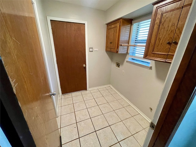 clothes washing area with light tile patterned floors, hookup for a washing machine, and cabinets