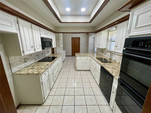 kitchen with backsplash, sink, black appliances, a tray ceiling, and light tile patterned flooring