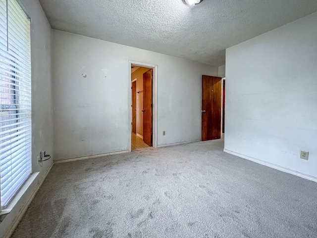 unfurnished room with a textured ceiling and carpet floors