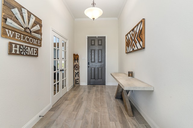 entryway featuring light wood-type flooring, ornamental molding, and french doors