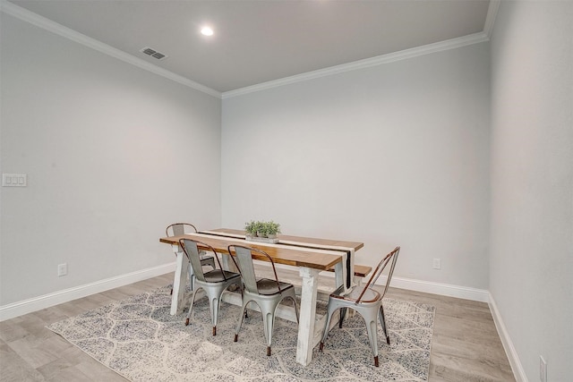 dining area featuring ornamental molding and light wood-type flooring