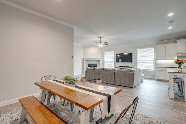 dining room featuring crown molding, ceiling fan, and light hardwood / wood-style floors