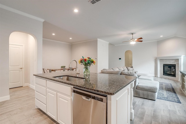 kitchen with white cabinetry, sink, stainless steel dishwasher, and an island with sink