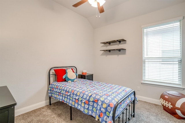 carpeted bedroom with ceiling fan, vaulted ceiling, and multiple windows