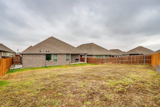 rear view of property featuring a lawn