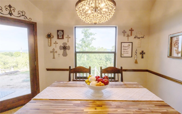 dining area featuring lofted ceiling, hardwood / wood-style floors, and a chandelier