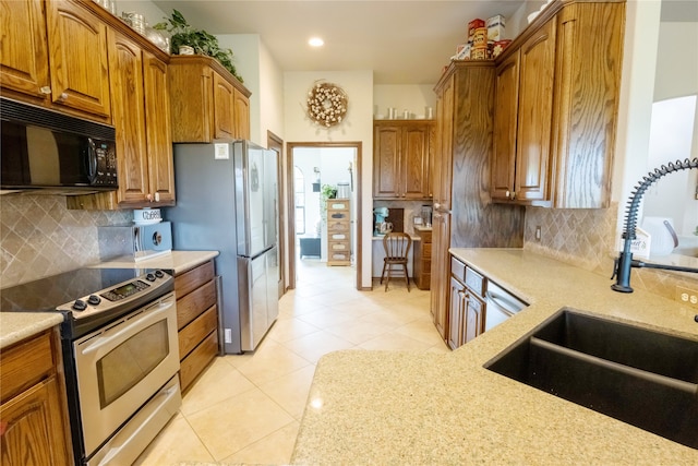 kitchen featuring light tile patterned floors, sink, stainless steel appliances, and decorative backsplash