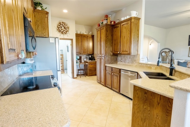 kitchen with light tile patterned flooring, sink, range, stainless steel dishwasher, and tasteful backsplash