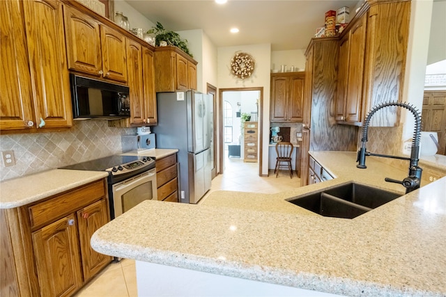 kitchen with sink, stainless steel appliances, light tile patterned floors, and backsplash