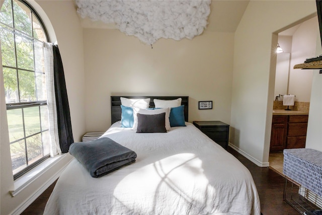 bedroom featuring hardwood / wood-style flooring and connected bathroom