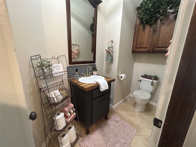 bathroom featuring tile patterned flooring, vanity, and toilet